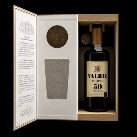 Open wooden gift box containing Valriz Porto 50 wine bottle with label, decorative medallion, and gray cloth liner on black background