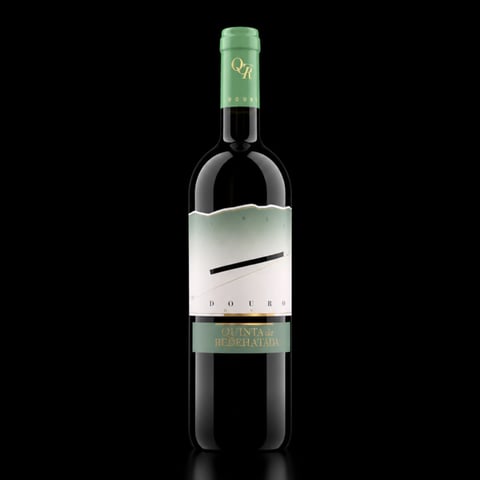 Bottle of red wine with green foil cap and minimalist white label featuring black brushstroke design against black background